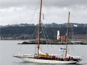 HMCS Oriole passes Fisgard Lighthouse in Victoria as the crew wave farewell as they start their journey to Halifax in a March 16, 2017 handout photo. The Royal Canadian Navy's longest serving commissioned vessel -- a sailing ketch that was launched abut 100 years ago - officially has a new home port.