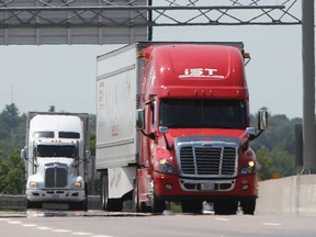 Transport trucks travel Highway 401 in the Kingston area on July 12, 2018.