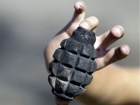 In this 2014 file photo, a boy shows an unexploded hand grenade in the Ukrainian village of Novosvitlivka.