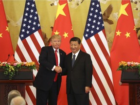 In this Nov. 9, 2017, file photo, U.S. President Donald Trump and Chinese President Xi Jinping shake hands during a news conference at the Great Hall of the People in Beijing. Trump's trade battle with China is creating domestic fallout in the U.S.