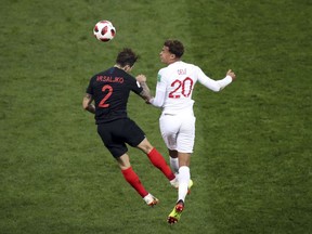 Croatia's Sime Vrsaljko jumps for the ball with England's Dele Alli, right, during the semifinal match between Croatia and England at the 2018 soccer World Cup in the Luzhniki Stadium in Moscow, Russia, Wednesday, July 11, 2018.