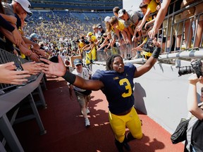 Rashan Gary of the Michigan Wolverines celebrates with fans after a 63-3 win over the Hawaii Warriors on Sept. 3, 2016 at Michigan Stadium in Ann Arbor, Michigan.
