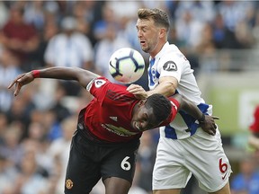 Manchester United's Paul Pogba, left, and Brighton's Dale Stephens battle for the ball during the English Premier League soccer match between Brighton and Hove Albion and Manchester United at the Amex stadium in Brighton, England, Sunday, Aug.19, 2018.