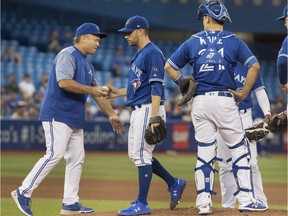 Toronto Blue Jays manager John Gibbons takes the ball from starting pitcher Marco Estrada in the sixth inning of their American League MLB baseball game against the Tampa Bay Rays, in Toronto on Friday, August 10, 2018.