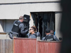Windsor police officers enter a garage in the 1500 block of Betts Avenue on Sept. 15, 2017. A 34-year-old Windsor man suspected of a shooting in Amherstburg was found inside dead from a self-inflicted gunshot.
