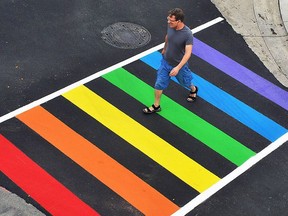 A pedestrian walks across the new rainbow crosswalk at Forsyth Street along King Street West in Chatham.