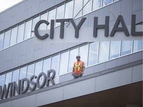 Finishing touches are made as workers install large 'Windsor City Hall' sign on to the new city hall building in downtown Windsor on July 19, 2018.