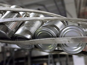 Canned processed pumpkins move along a conveyor belt in the case and label area of a cannery in Morton, Ill. Canned food companies say they are eyeing increasing prices to combat the affects of aluminum tariffs.