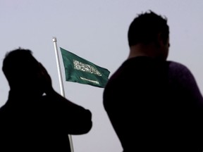 People pray at an open air makeshift mosque in front of a giant Saudi Flag in Jiddah, Saudi Arabia on June 21, 2017.