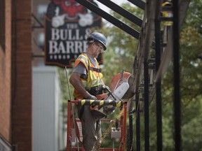 Construction crews dismantle the large patio at the Bull & Barrel on Aug. 20, 2018, to prepare for streetscaping on the east side of Ouellette Ave, south of Wyandotte Street.