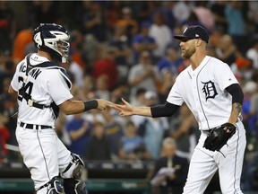 Detroit Tigers catcher James McCann and relief pitcher Shane Greene celebrate beating the Chicago Cubs 2-1 after a baseball game in Detroit, Tuesday, Aug. 21, 2018.