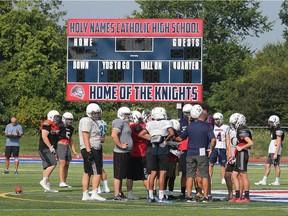 The Holy Names Catholic High's football team practices near the scoreboard of the school's new turf field Aug. 28, 2018.