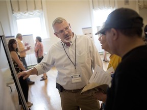 Allan Campbell, director of permitting at Kinder Morgan, talks with people attending Kinder Morgan's Detroit River Crossing Replacement Project open house at Mackenzie Hall Cultural Centre, Tuesday, Aug. 28, 2018.
