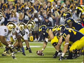 In this Sept. 7, 2013, file photo, Michigan offensive lineman Jack Miller (60) prepares to snap the football to quarterback Devin Gardner (98) as they face Notre Dame in Ann Arbor, Mich. (AP Photo/Tony Ding, File)