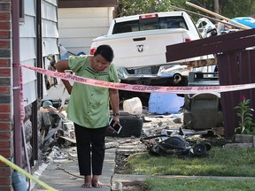 A woman checks out the damage to a house on the corner of Moy Avenue and Cataraqui Street on Aug. 2, 2018. A pickup truck jumped the curb, struck the side of the house, took out a fence and ended up in the backyard. The crash occurred at approximately 4:30 p.m. and no serious injuries were reported. Police on scene noted that it could have been a deadly accident if any pedestrian had been in the path of the truck.