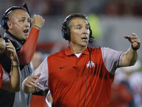 FILE - In this Sept. 17, 2016, file photo, Ohio State head coach Urban Meyer, right, and then-assistant coach Zach Smith, left, gesture from the sidelines during an NCAA college football game against Oklahoma in Norman, Okla. What has transpired over the last three weeks at Ohio State should be a lesson to all coaches. Your football program is not a family. Urban Meyer treated Zach Smith like family, and it almost cost one of the most accomplished coaches in college football his job.