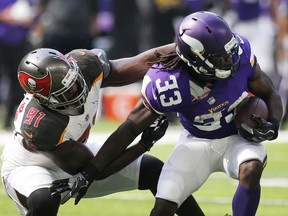 FILE - In this Sept. 24, 2017, file photo, Minnesota Vikings running back Dalvin Cook (33) tries to break a tackle by Tampa Bay Buccaneers defensive end Robert Ayers (91) during the first half of an NFL football game in Minneapolis. The Detroit Lions have signed free agent Ayers. He is entering his 10th NFL season.