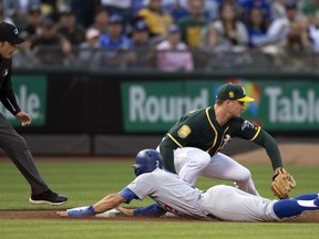 Los Angeles Dodgers' Chris Taylor (3) slides safely into third base ahead of the relay to Oakland Athletics third baseman Matt Chapman during the second inning of a baseball game Tuesday, Aug. 7, 2018, in Oakland, Calif. At left is umpire Jansen Visconti.