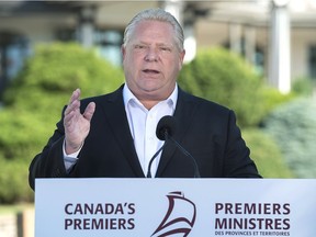 Ontario Premier Doug Ford talks with reporters at the Canadian premiers meeting in St. Andrews, N.B. on In this July 19, 2018.