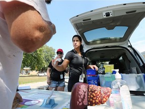 Rola Osman, a hepatitis C outreach worker with the Windsor Essex Community Health Centre's Street Health organization hands out clean needles to a man in a housing complex on Campbell Avenue. Rola and a volunteer pack up a minivan with an assortment of supplies and hand them out to low income individuals throughout the community.