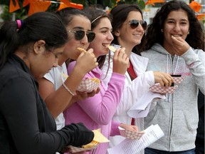 Windsor Stroll participants Leila Fawaz, left to right, Joya Salibi, Maya Mikhael, Tia Salibi and Mia Nour eat nachos from the Walkerville Tavern on Sept. 8, 2018. The Walkerville Tavern invited visitors to "Knock for Nachos" where visitors were treated to free water and nachos.