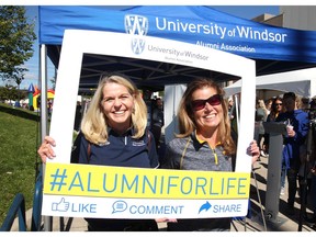 Windsor, Ontario.  September 29, 2018.   University of Windsor alumni Beth Oakley, left, and Sue Williams share a photo frame while participating in the 2018 Homecoming party at Alumni Field prior to the Lancers football game against U of Toronto September 29, 2018.(NICK BRANCACCIO/Windsor Star).