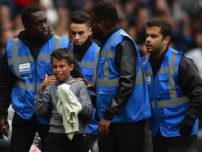 A young PSG fan cries as he is accompanied by stadium employees after his intrusion on the pitch to meet Paris Saint-Germain's Brazilian forward Neymar who gave him his jersey as he was leaving the pitch during the French L1 football match between Rennes and Paris Saint-Germain at the Roazhon Park stadium in Rennes, on September 23, 2018.