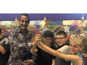 Windsor philanthropist Al Quesnel high-fives some youngsters Friday, Sept. 21, 2018, at the Big Brothers Big Sisters of Windsor Essex office on Jefferson Boulevard. Quesnel donated $500,000 to the organization.