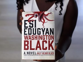 Canadian novelist Esi Edugyan holds her book as she is photographed at home in Victoria, B.C., on Aug. 27, 2018.