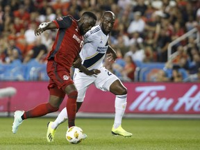 Toronto FC forward Jozy Altidore and Los Angeles Galaxy defender Michael Ciani battle for the ball second half of MLS soccer action, in Toronto on Sept. 15, 2018.