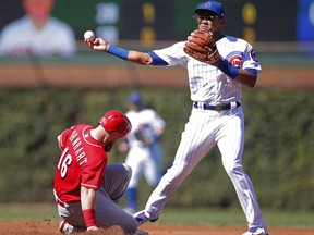 Cincinnati Reds' Tucker Barnhart, left, is out at second base as Chicago Cubs' Addison Russell makes the throw to first base during the fourth inning of a baseball game Sunday, Sept. 16, 2018, in Chicago.