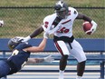 Andrew Beatty, left, of the University of Windsor collars Phil Iloki of the Carleton Ravens during Monday's OUA football game at Alumni Field.