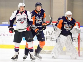 Rookie forward Will Cuylle, who was acquired by the Windsor Spitfires on Friday, battles for position with Flint Firebirds defenceman Nikita Alexandrov on Sunday in front of goalie Evan Morrison in Buffalo. Windsor won the game 7-4 to go 3-0 at the OHL Showcase.