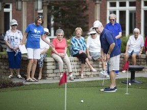 Ross Garrod, 86, putts while the rest of the golfing league look on at Putting with Sue at the Chartwell St. Clair Beach Retirement Residence on Sept. 17, 2018.
