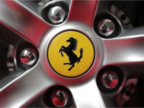 FILE - This Monday, Oct. 9, 2017 file photo shows a Ferrari logo on a car outside the New York Stock Exchange in New York. Ferrari is blazing its future under new leadership on limited edition cars based on iconic models of the past, unveiling on Tuesday Sept. 18, 2018, the first in the Icona special series billed as the most-powerful road car in the company's history.