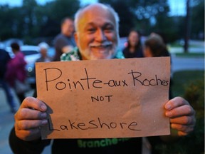 Jean Tremblay of Stoney Point (Pointe-aux-Roches) holds up a sign at the Lakeshore council meeting on Tuesday, Sept. 25, 2018.