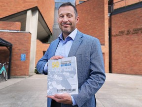 Christopher Watters, Dean of Law at the University of Windsor, is shown with a commemorative 50th anniversary book at the school on Sept. 17, 2018.