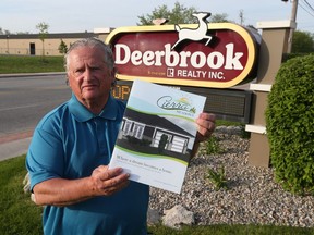 In this May 16, 2017, file photo, Mario DeMarco of Deerbrook Realty Inc.  displays a brochure on a new multi-unit residential development for Windsor.