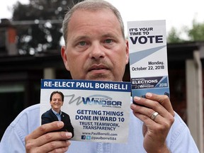 Michael Patterson, Windsor council candidate for Ward 10, holds a re-election campaign brochure for Ward 10's incumbent, Paul Borrelli (left) and an official election pamphlet from the City of Windsor (right). Patterson has filed a complaint about Borrelli's use of the City of Windsor logo, which Patterson says is in violation of several council and election rules. Photo taken Sept. 13, 2018.