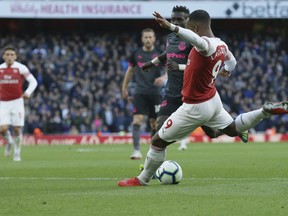 Alexandre Lacazette prepares to shoot to score the opening goal during an English Premier League soccer match between Arsenal and Everton at the Emirates Stadium in London, Sunday Sept. 23, 2018.