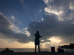 A man casts his line while fishing off the pier at the Colchester Harbour Marina July 31, 2016.