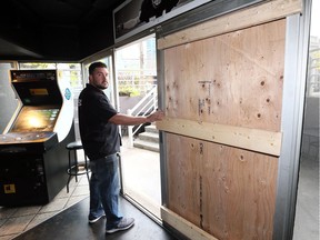 Nicolas Puim, owner of The Dugout, stands beside his boarded-up front door on Oct. 6, 2018, after thieves crashed through the $1,400 door and burlarized the downtown bar early last Wednesday.