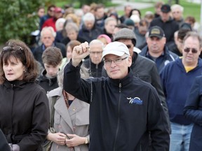 Dan Bianchi holds his rosary high during a procession from Bert Weeks Memorial Gardens along the Windsor riverfront, part of the Coast to Coast Rosary Rally on Oct. 7, 2018.