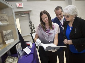 From left, Nicole Hutchinson, Bill Marra, Vice President of Hôtel-Dieu Grace Healthcare for External Affairs, and CEO Janice Kaffer, take a look through a yearbook from 1935, entitled 'The Lamp' on the eve of Hôtel-Dieu Grace Healthcare 130th anniversary celebration, Tuesday, Oct. 16, 2018.