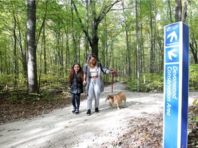 Leila Chase, 7, left, Linda Nguyen and their pet Boogers, take a walk along the Caesars Windsor nature trail at Devonwood Oct. 25, 2018.