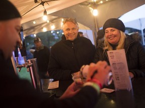 Greg Grondin from GL Heritage Brewery, pours some Ry-ed Ale for Faye Dunn and Ari Varsa, centre, while at the Windsor Craft Beer Festival at Willistead Park, Friday, Oct. 12, 2018.