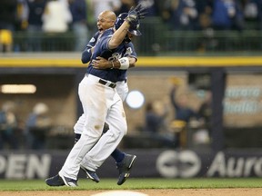 Milwaukee Brewers' Mike Moustakas celebrates with teammate Keon Broxton after he hit a walk off single in the 10th inning to win Game One of the National League Division Series at Miller Park on Oct. 4, 2018 in Milwaukee, Wis.