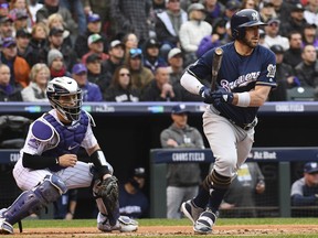 Milwaukee Brewers' Travis Shaw, right, grounds out to drive in a run off Colorado Rockies starting pitcher German Marquez in the first inning of Game 3 of a baseball National League Division Series Sunday, Oct. 7, 2018, in Denver.