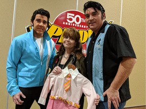 Elvis tribute artist Pete Doiron (left) and Norm Ackland Jr. (right) stand with Victoria Paige Meyerink, a former child actress who co-starred with Elvis in the 1968 film Speedway, at the Hellenic Cultural Centre for the 12th annual Kingfest. Meyerink holds the dress she wore in the film when she was six.