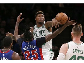 Boston Celtics guard Marcus Smart (36) fouls Detroit Pistons guard Reggie Bullock (25) as he tries to block a shot during the first half of an NBA basketball game, Tuesday, Oct. 30, 2018, in Boston.